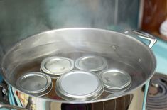 a pot filled with lots of tin cans sitting on top of a stove burner