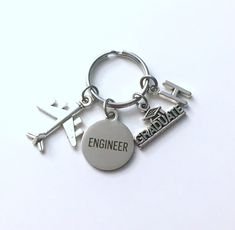 an airplane keychain with the word engineer on it and two keys attached to it