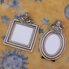 two silver frames sitting next to each other on top of a yellow wallpaper covered floor