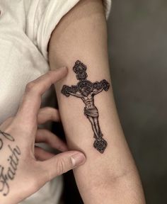 a person with a cross tattoo on their arm