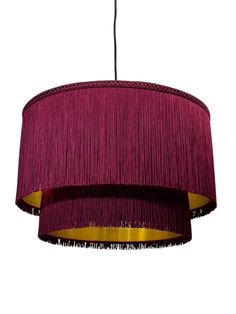 a purple chandelier hanging from the ceiling with fringes on it's sides