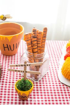 a table topped with lots of fake carrots on top of a red and white checkered table cloth