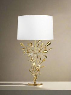 a lamp that is on top of a table with a white shade over the lamp