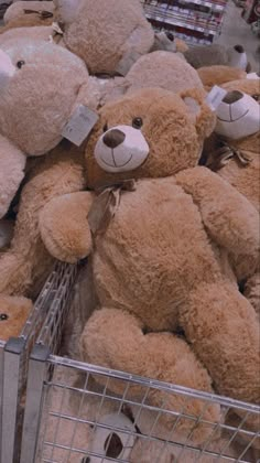 a pile of stuffed teddy bears sitting in a shopping cart with tags on their ears