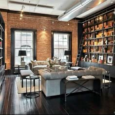 a living room filled with lots of furniture and bookshelves next to a window