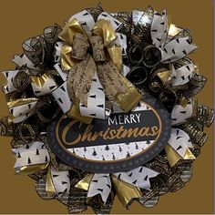 a merry christmas wreath with gold and black bows