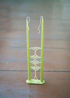 a pair of green candles sitting on top of a wooden table