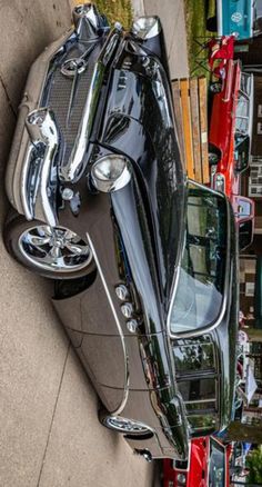 an old car is parked on the side of the road next to some other cars