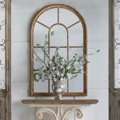 a vase filled with flowers sitting on top of a white table next to a window