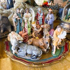 there are many figurines on the table in front of them, including jesus and other animals