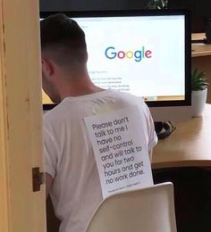 a man sitting in front of a computer with a t - shirt that says google on it