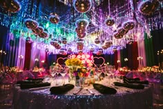 a table set up for a party with disco balls and lights hanging from the ceiling