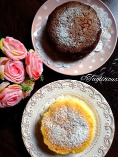 two plates topped with cakes next to pink roses