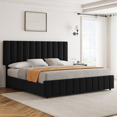 a large bed sitting on top of a hard wood floor next to a white wall