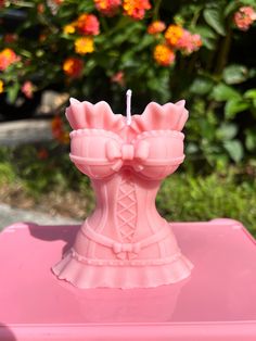 a pink candle holder with a bow on it