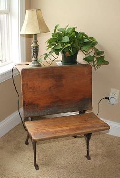 an old wooden bench next to a window with a lamp on it and a potted plant in the corner