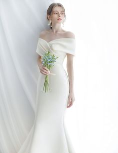 a woman in a white dress holding a bouquet of flowers