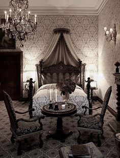 a bed room with a neatly made bed and chandelier