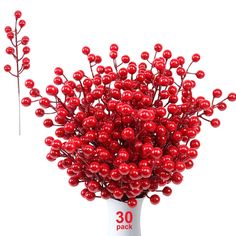 a vase filled with red balls on top of a white table