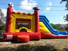 an inflatable soccer ball bouncer set up on the lawn for kids to play