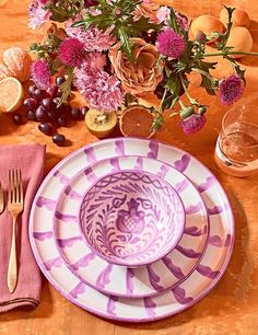 the table is set with flowers and fruit