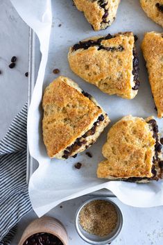 blueberry scones on parchment paper next to bowl of chocolate chips