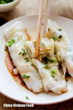 a white plate topped with dumplings and chopsticks