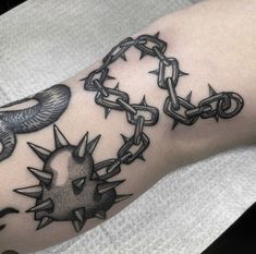 a tattoo on the arm of a person with chain and doves attached to it