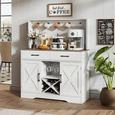 a white cabinet with wine glasses on it in a living room next to a potted plant