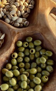 olives and pistachios in bowls on a wooden tray