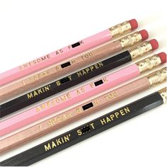 four pencils with writing on them are lined up in a row and one is pink