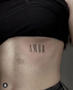 a woman's stomach with the word amr tattooed on her lower side belly