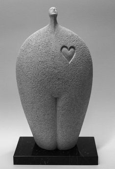 a large gray sculpture with a heart on it's back