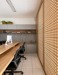 an office with wooden desks and chairs in front of a wall made out of circles