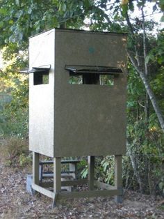 an outhouse in the woods with trees around it