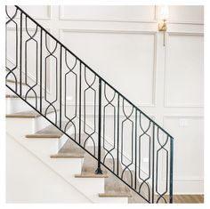 a stair case with wrought iron handrails and wood flooring in an empty room