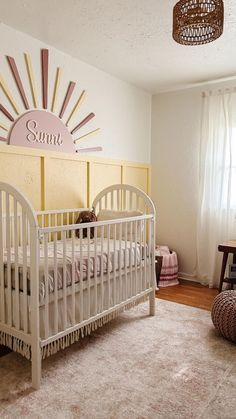 a baby's room with sunburst above the crib and rug on the floor