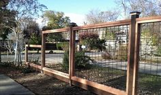 the fence is made of wood and has metal bars on each side, along with plants