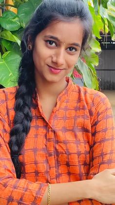 a woman in an orange shirt is smiling