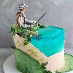 a cake with a man fishing on the top and green frosting in the middle