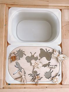 a bathtub with wooden cutouts in the shape of bugs and honeybees