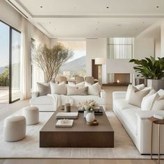 a living room filled with white furniture and large windows