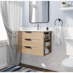 a white toilet sitting next to a bathroom sink under a mirror on top of a wooden cabinet