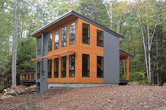 a modern home built in the woods surrounded by trees