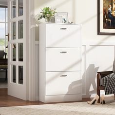 a living room with white furniture and a painting on the wall next to a chair