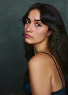 a woman with long black hair is posing for the camera