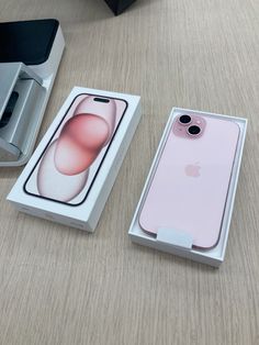 an apple phone in its box next to it's packaging on a wooden table