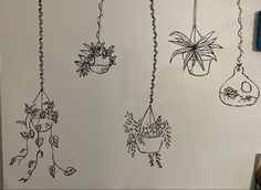 several hanging plants are drawn on the wall next to a blue marker and some scissors