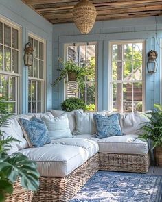 a living room filled with lots of furniture and plants on top of it's windows