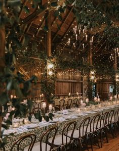 a long table is set up with candles and greenery for an elegant wedding reception